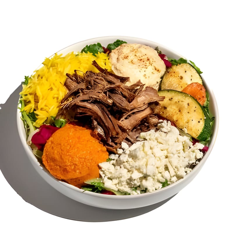 Mediterranean bowl with shredded beef, yellow rice, hummus, feta, and grilled vegetables.