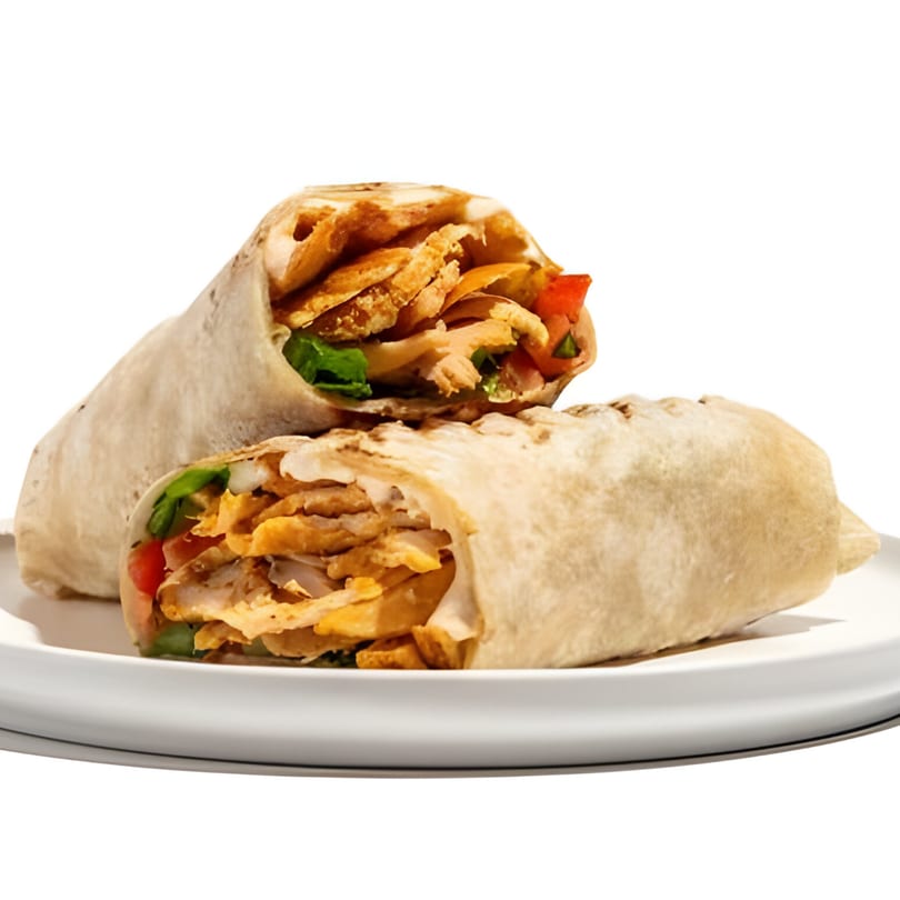 Two Wild Pita chicken shawarma wraps, filled with meat, fries, and vegetables, on a white plate.